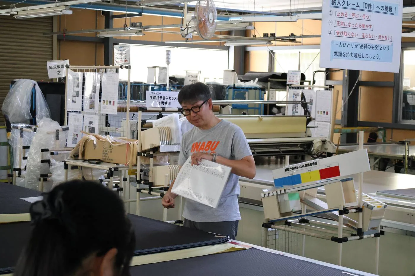 トヨタケ工業の工場で、経営者の案内を受けながら設備を見る参加者