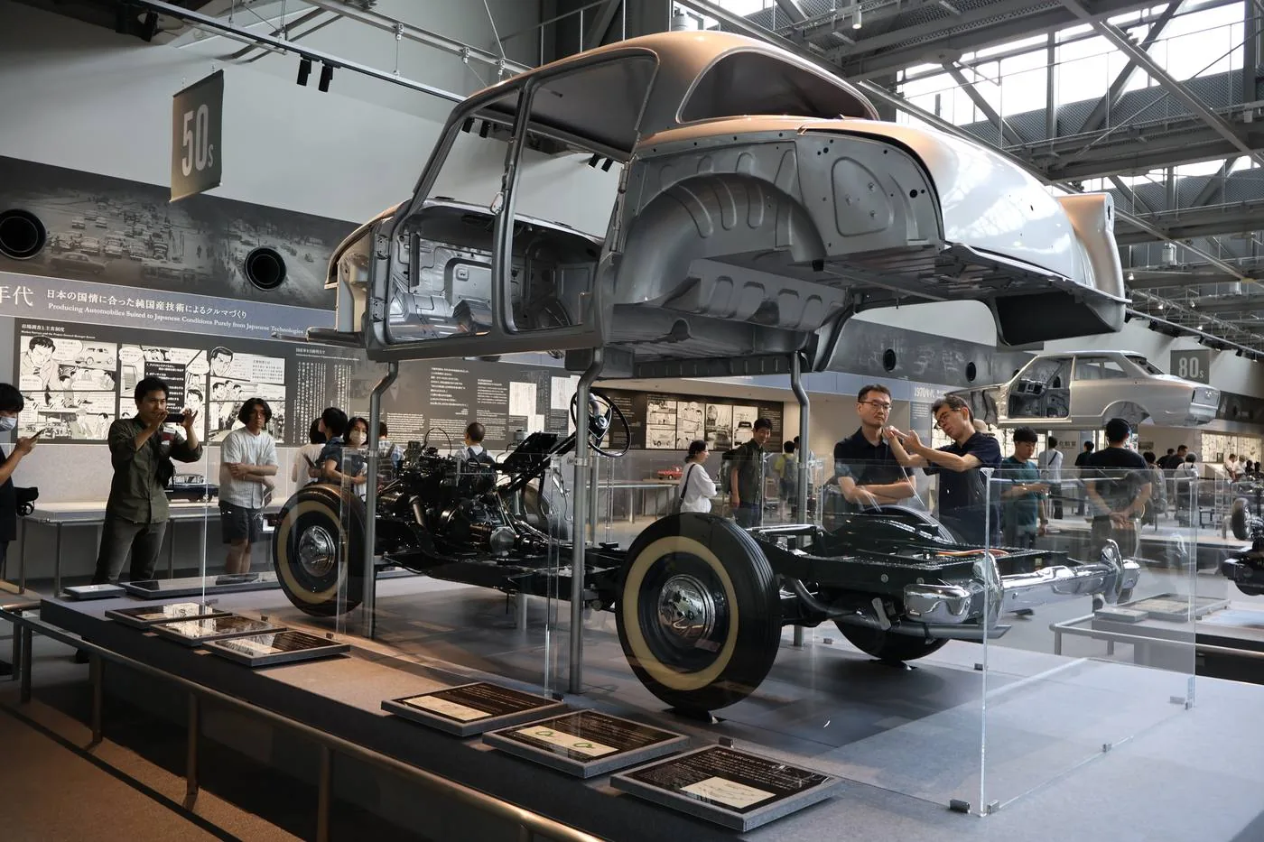 トヨタ産業技術記念館で、自動車の展示を見学する参加者