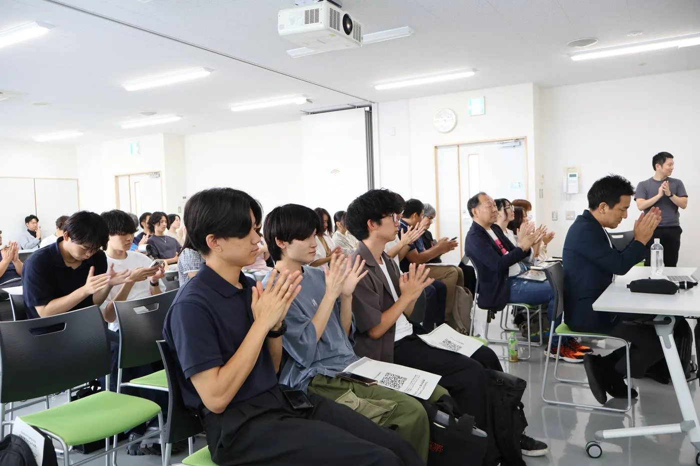 成果発表会で、発表した仲間に拍手を送る参加者