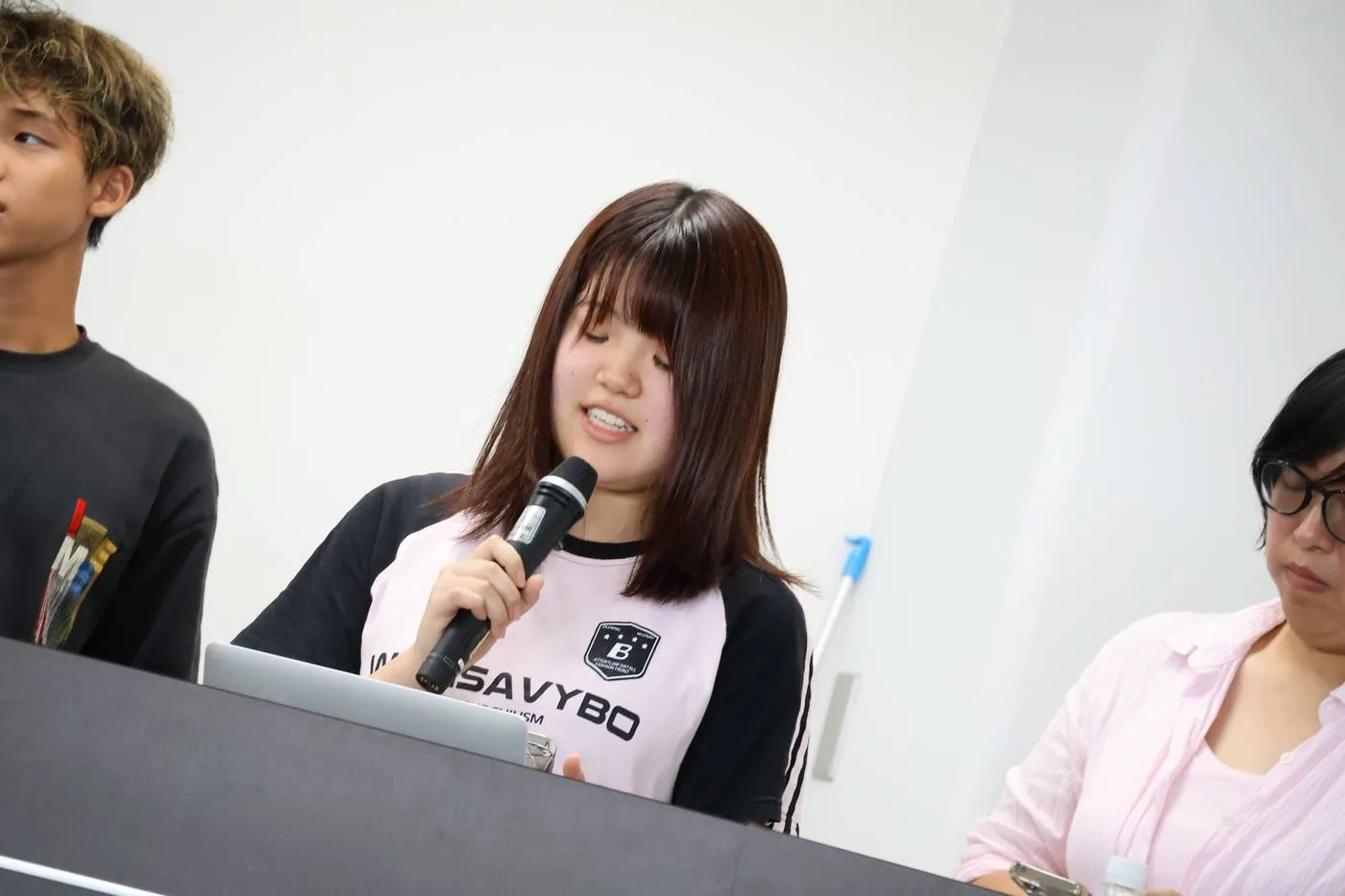 Day4の成果発表会で、参加者がマイクを持って自分たちの事業案を説明する