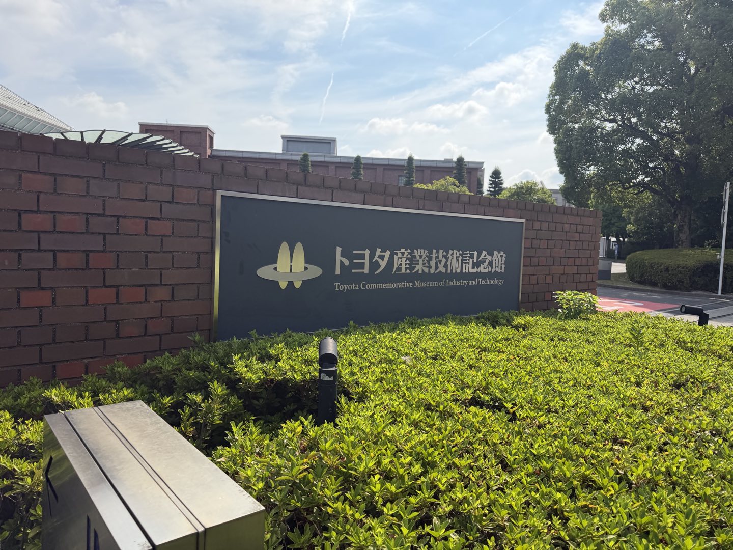 「トヨタ産業技術記念館」と刻まれた入口の銘板と、その奥に見える館の建物