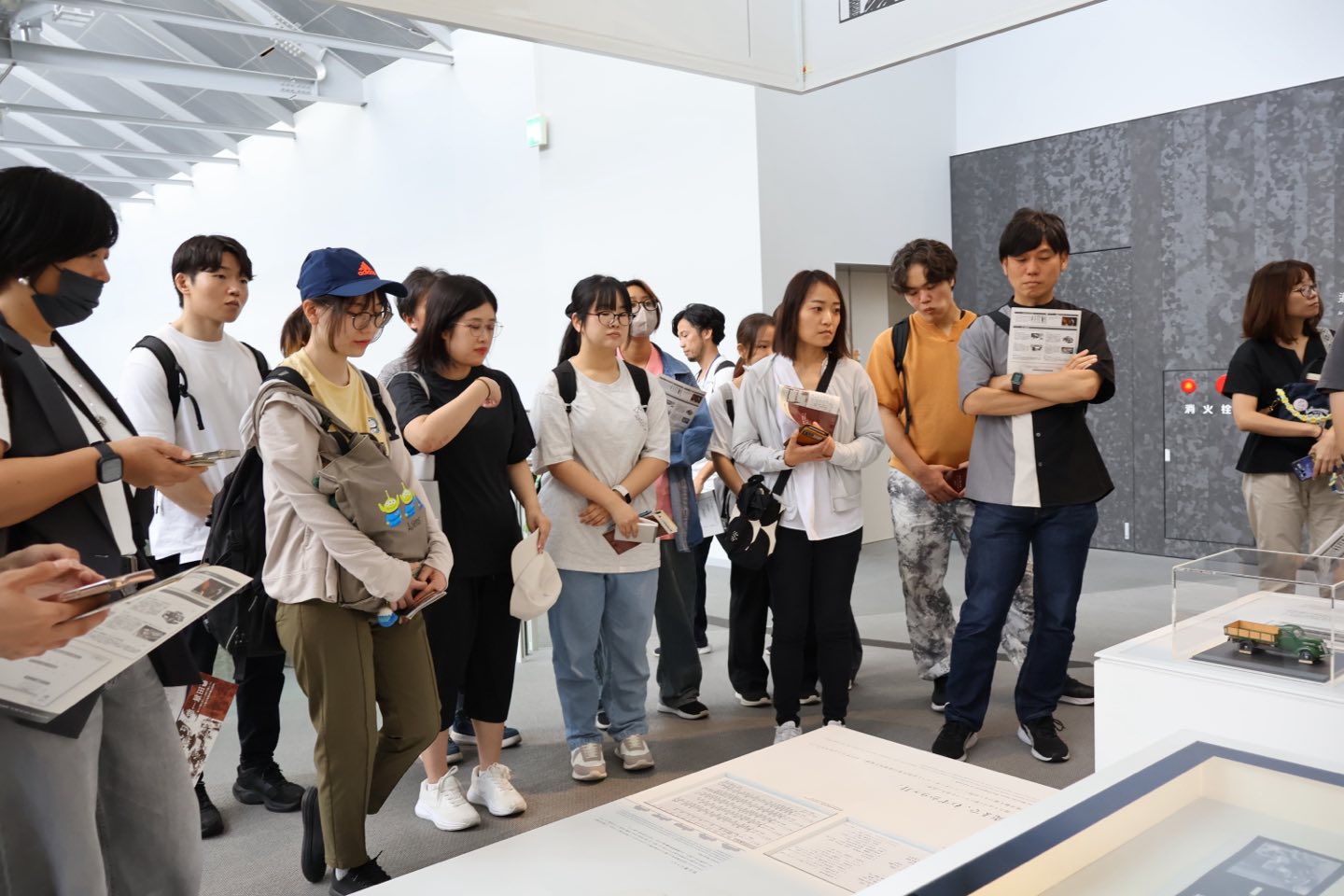 展示の前に集まった参加者たちが、解説に耳を傾けている様子