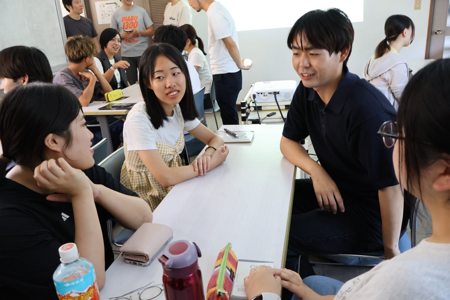 会議室のテーブルを囲み、チームごとに議論する参加者たち