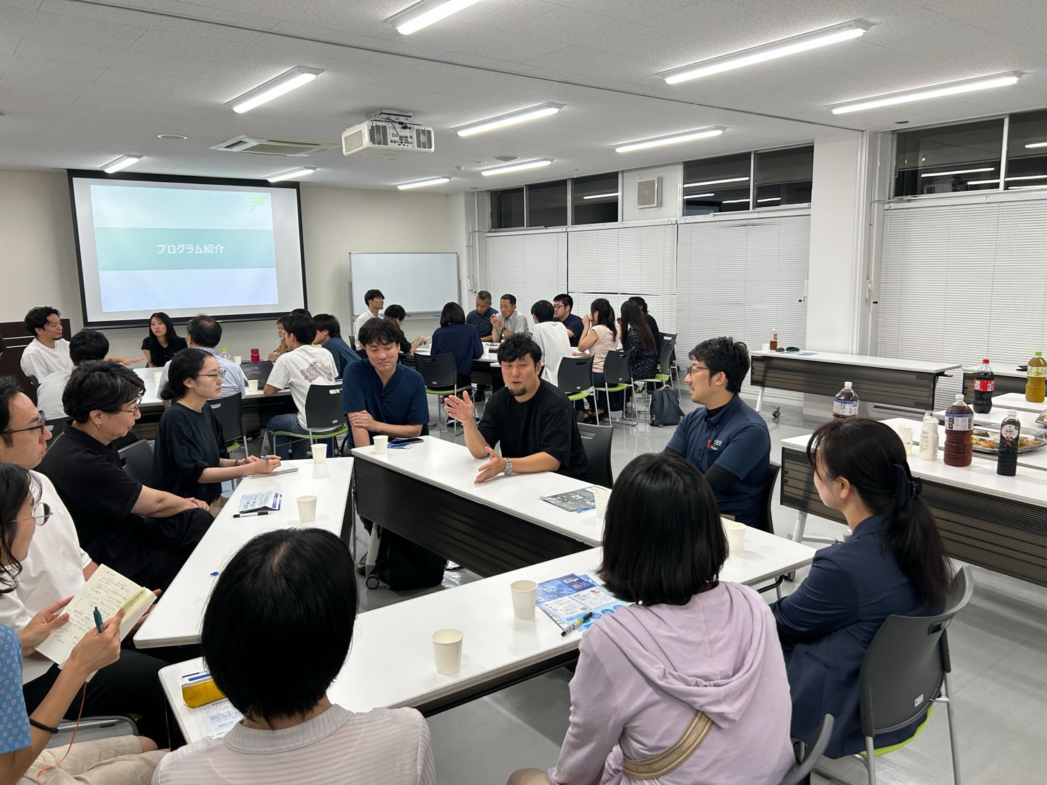 TAKEOFFの参加者や関係者がテーブルを囲み、事業について話し合う様子